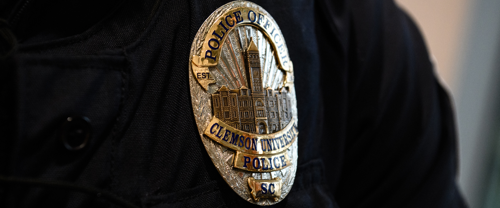 An upclose view of a Clemson University police officer badge pinned on an officer's shirt.