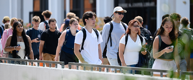 Students walk to and from class across library bridge.