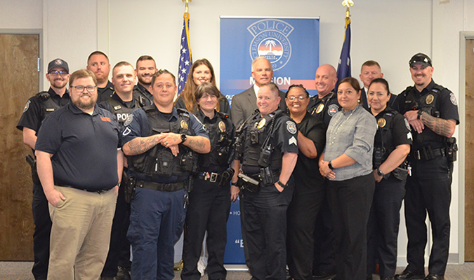 Officers posing in front of the American and SC state flags.