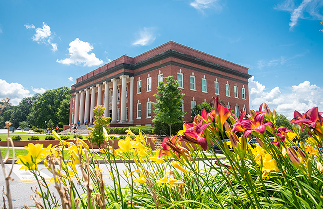 Sikes Hall with flowers blooming across the street.