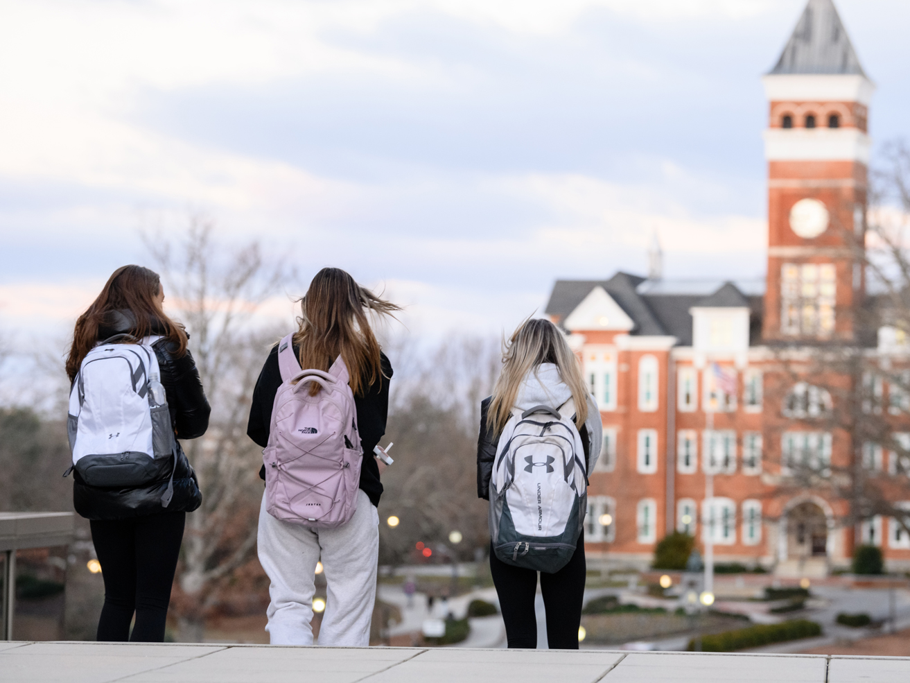 Three female students walking on campus on a winter morning