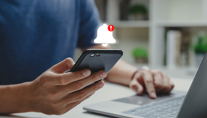 A man holding a smartphone that has just received an emergency alert