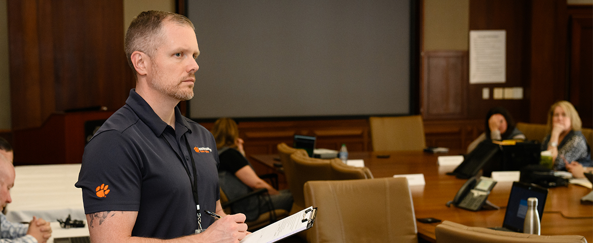 A female emergency responders faces an auditorium on police officers during an exercise on Clemson's campus.