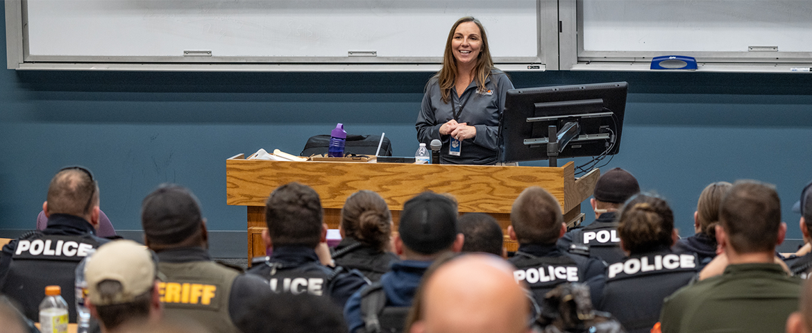 A female emergency responders faces an auditorium on police officers during an exercise on Clemson's campus.