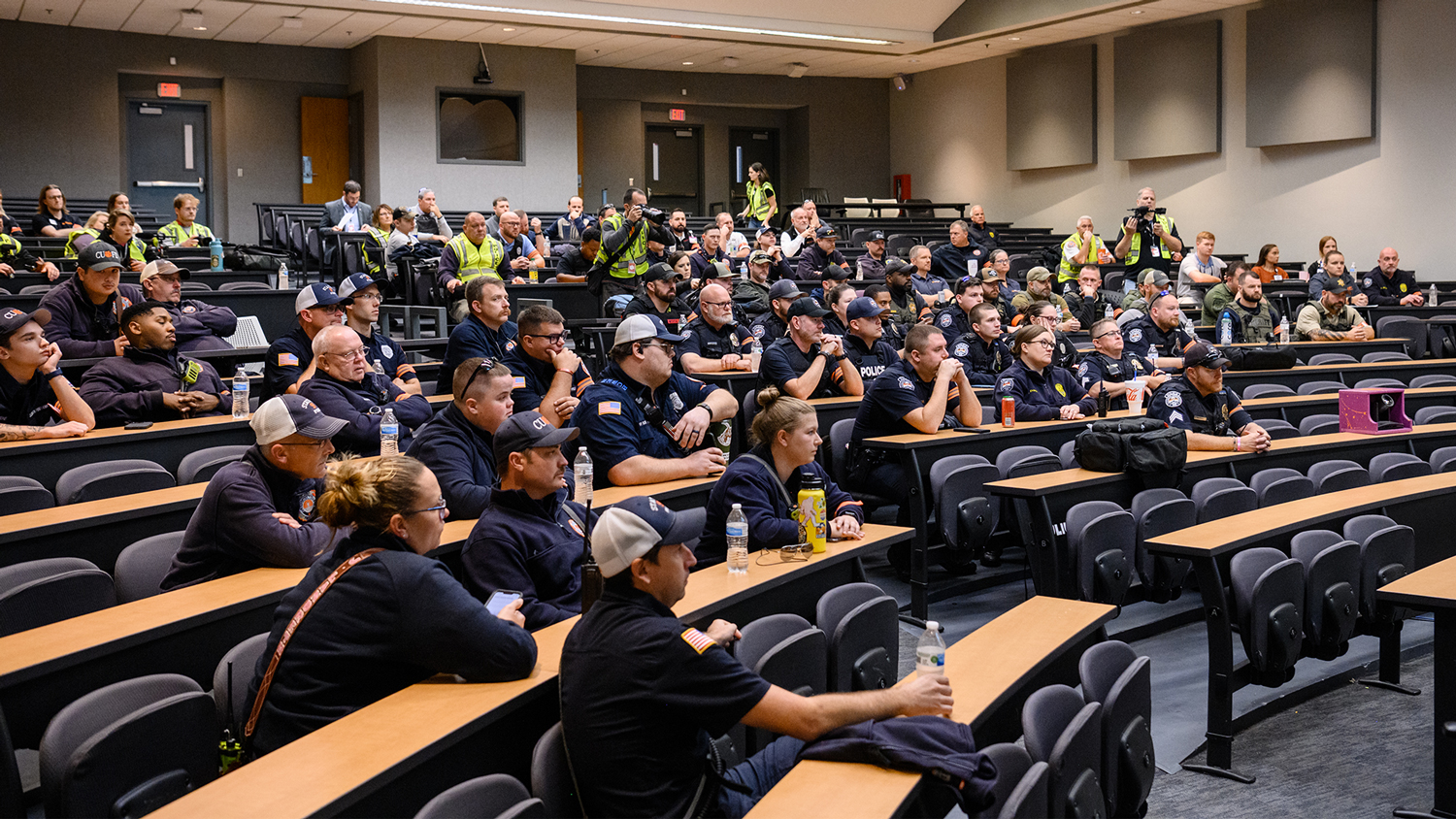 A large group of first responders and Clemson University staff listen to a briefing.