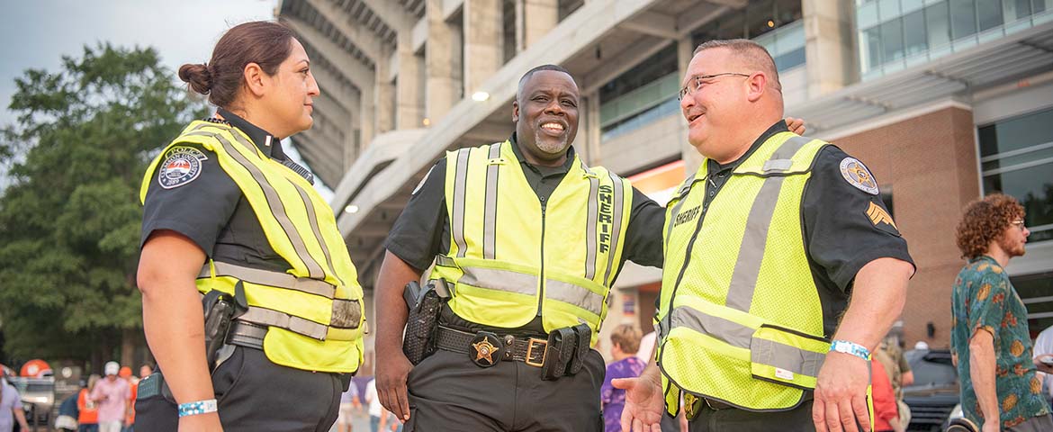 Three police officers share a laugh outside of the stadium.