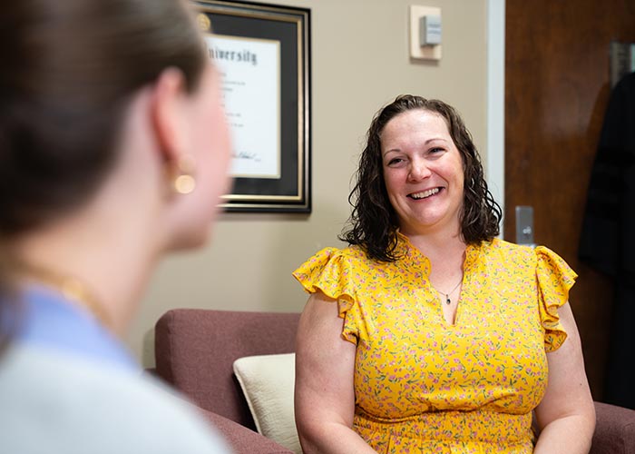 CAPS counselor smiles while talking with a student