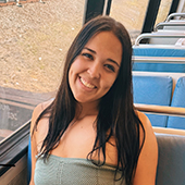 Young woman smiling while sitting on a bus.