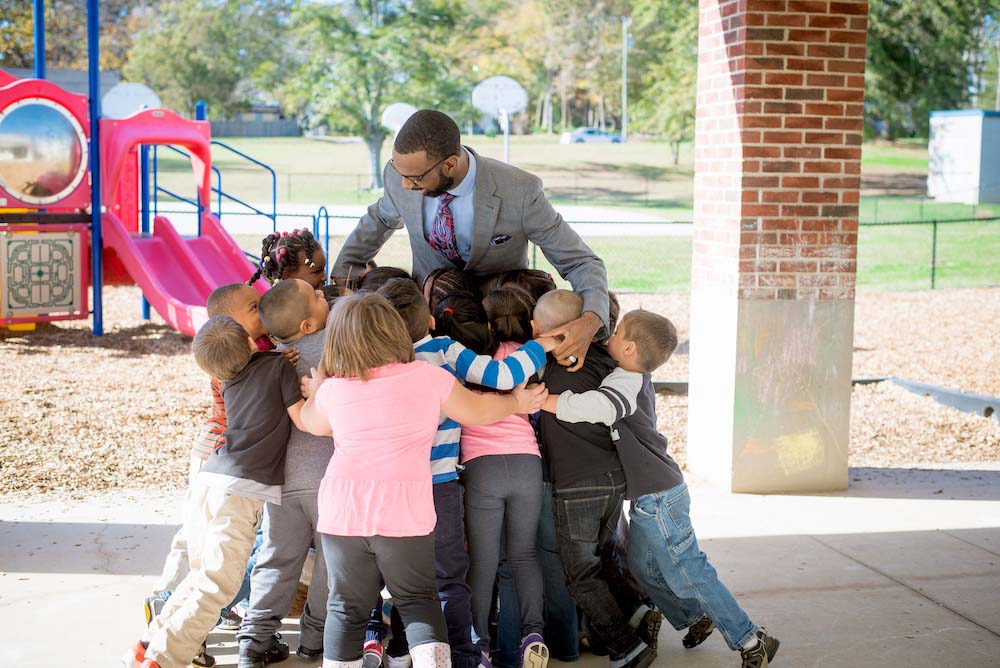 Students hugging a Clemson University Student Graduate teacher