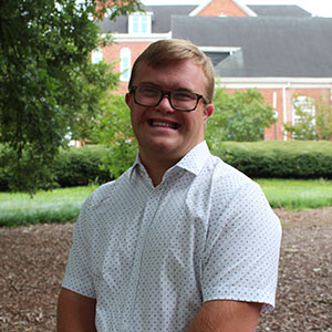 Smiling student in an outdoor garden area.
