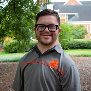 Smiling student in an outdoor garden area.
