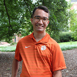 Smiling student in an outdoor garden area.