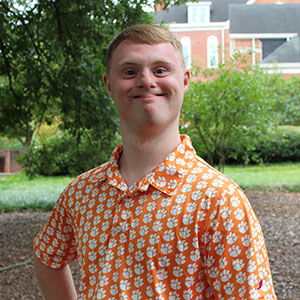 Smiling student in an outdoor garden area.