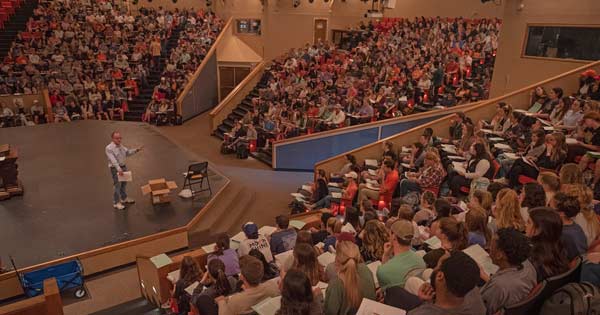 Person speaking to a large lecture hall