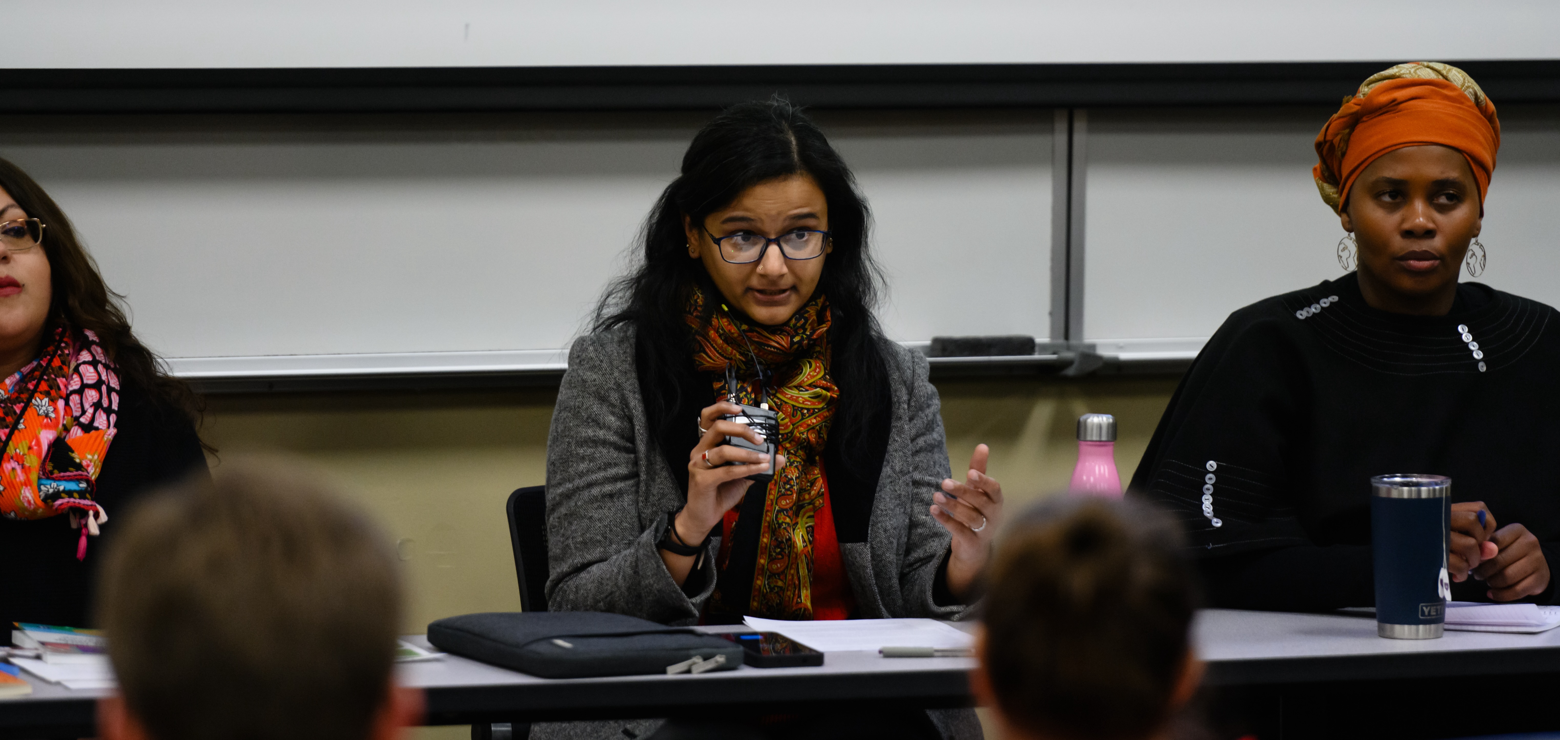 A close shot of a panelist seated at a table and speaking