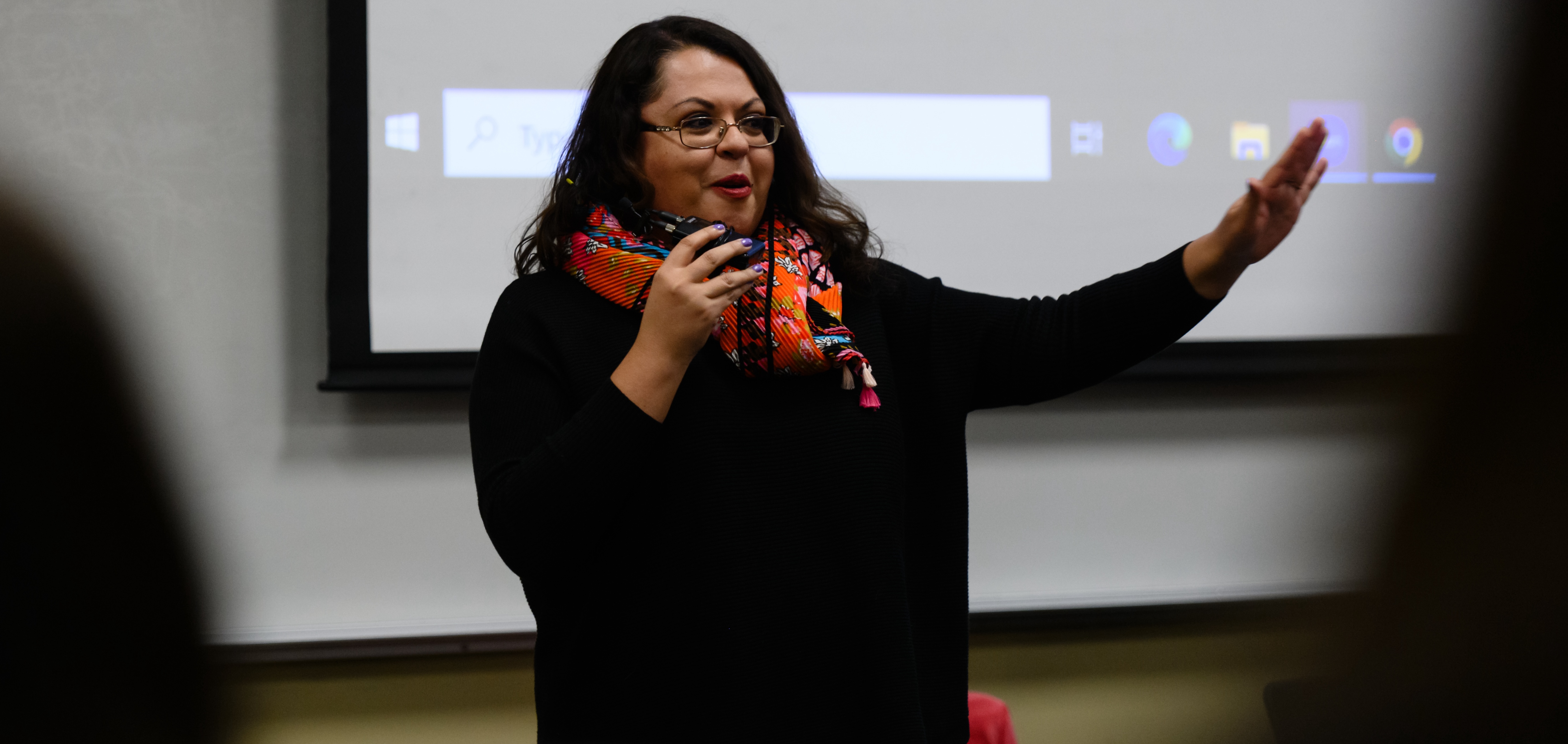 A panelist gesturing to the audience while standing and speaking