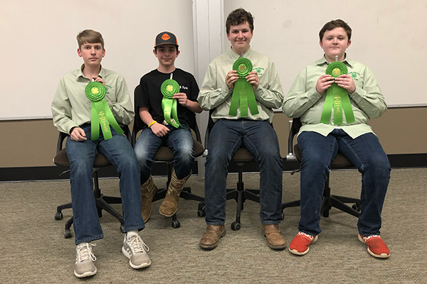 Boys holding prize ribbons