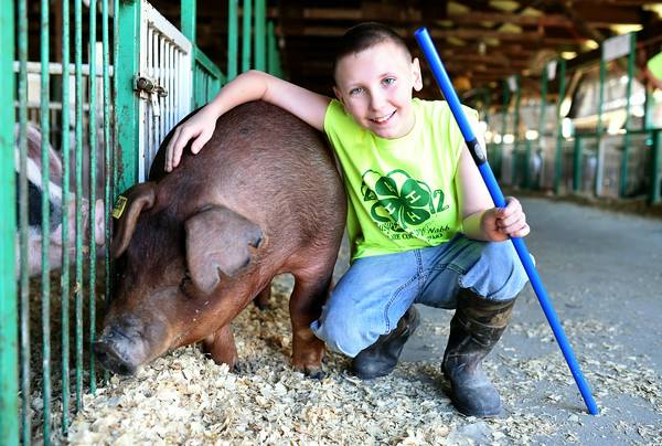 boy posing with his hog
