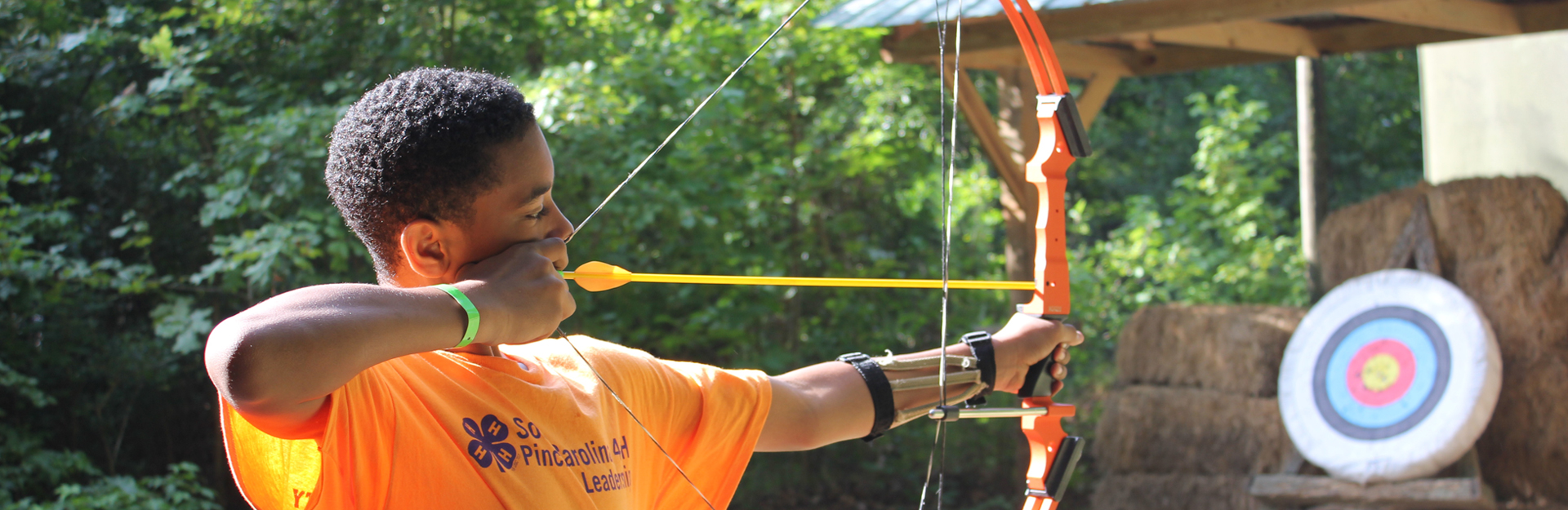 student aiming a bow at a target