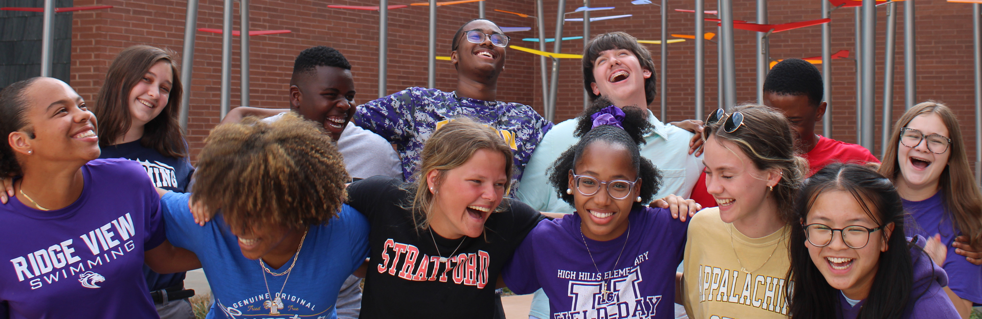 4 h students standing arm in arm laughing