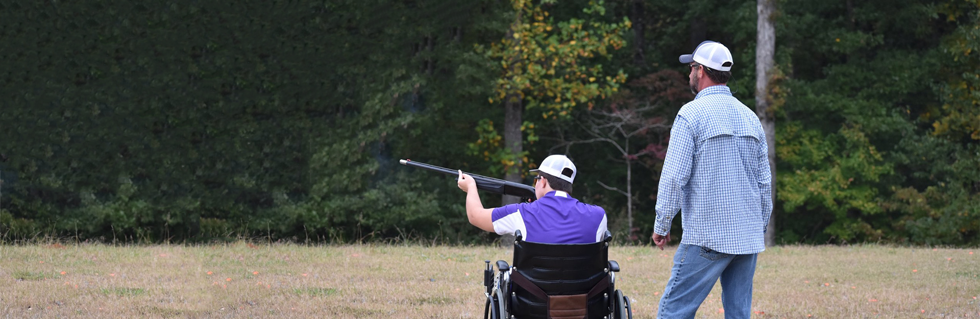 young man at a shooting competition with an adult supervising