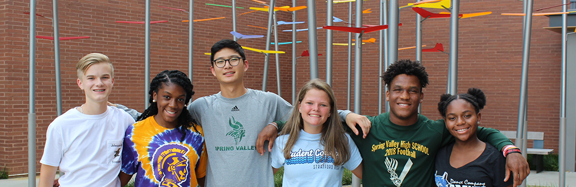 students standing arm-in-arm smiling