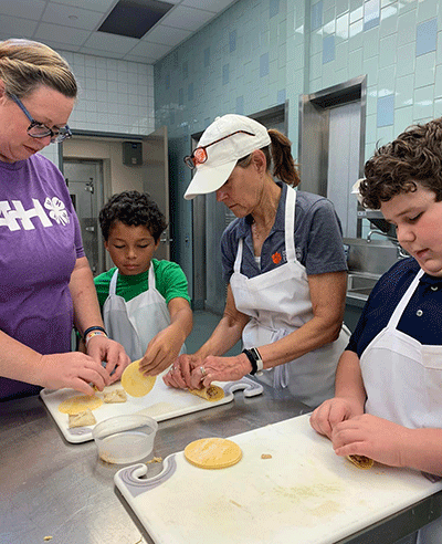 adults helping kids cook