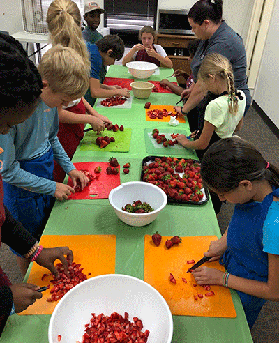 Kids cutting strawberries