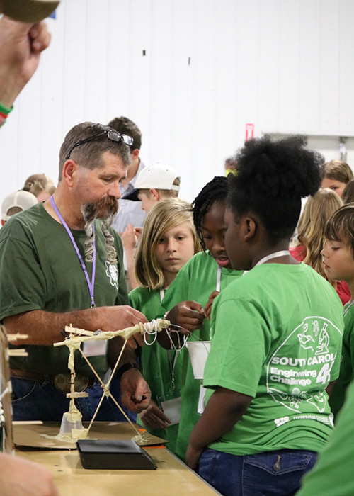 kids showing adult their project