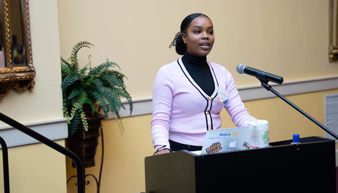 young woman speaking from a podium