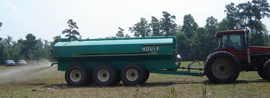 Image of a liquid manure spreader operating behind a tractor.