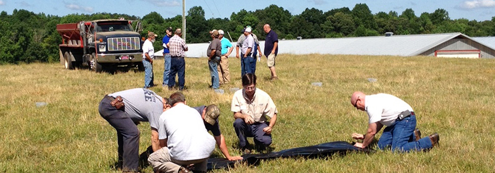 Image of farmers and a manure spreader truck, setting up for a spreader calibration run.