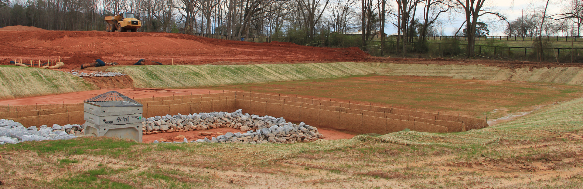 construction site with exposed soil and barriers in place to protect drains