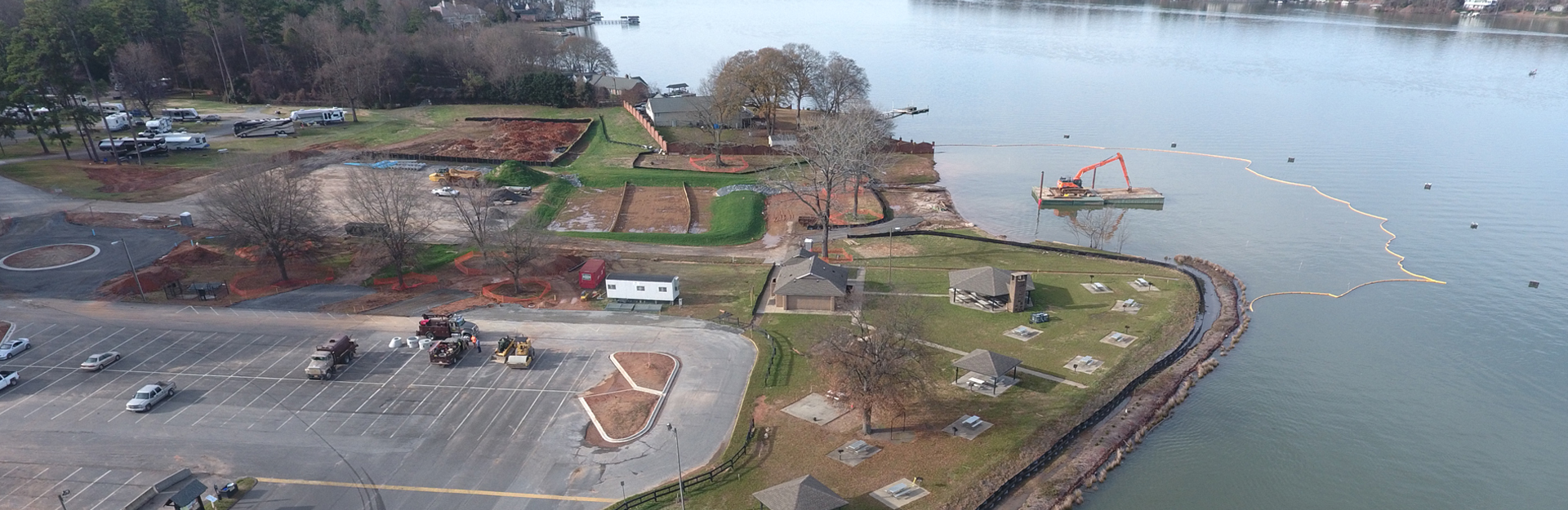 lakeside construction site with exposed soil and barriers in place to protect drains