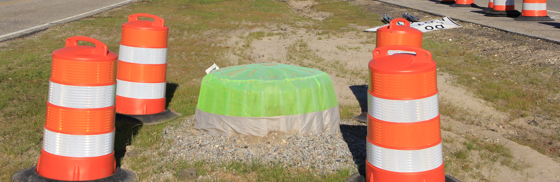 close up of water drainage and exposed soil barriers in the median of a roadway 