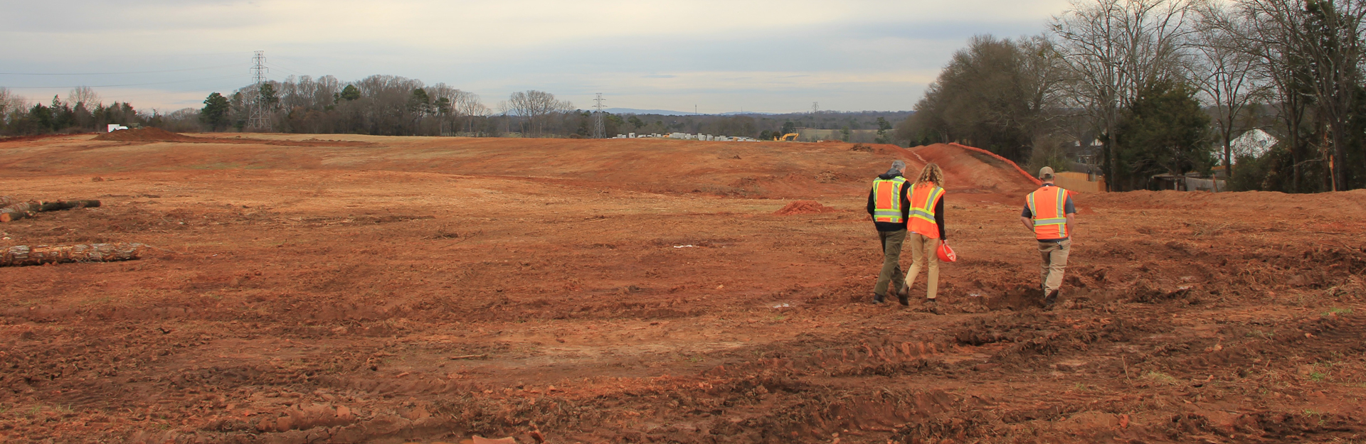 inspectors walking around a construction site with exposed soil