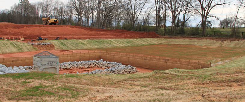 construction site with exposed soil and a water drain