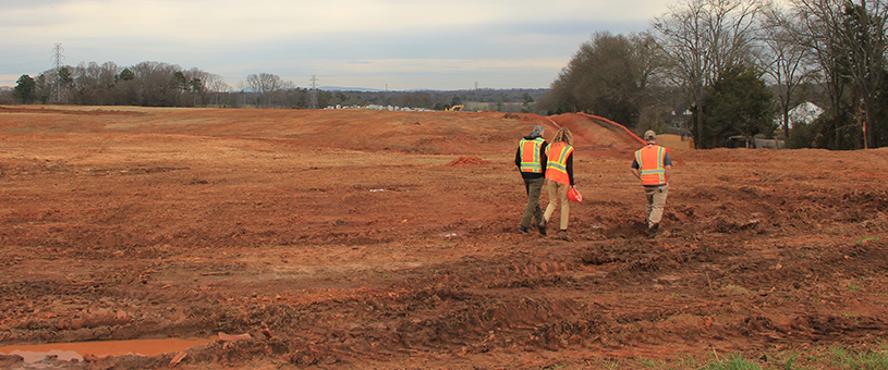 people walking on exposed soil at a construction site