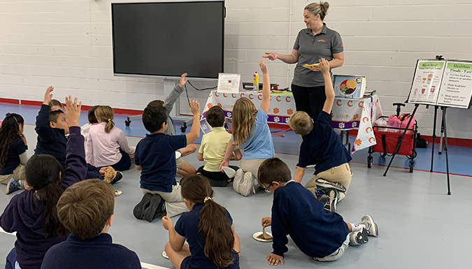 Woman stands in front of group of students in a classroom