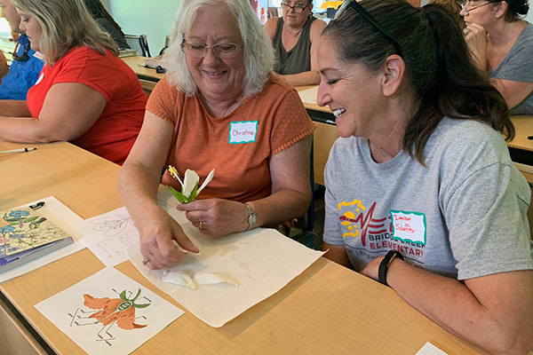 Two women in a Master Gardener class working on a flower lesson