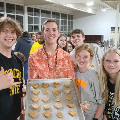 vet camp student holding a large baking sheet with homemade dog treats on it