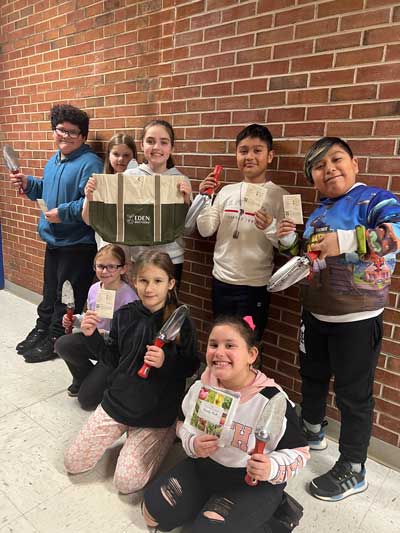 elementary schools students showing their gardening supplies