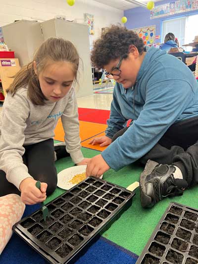 two students starting seeds