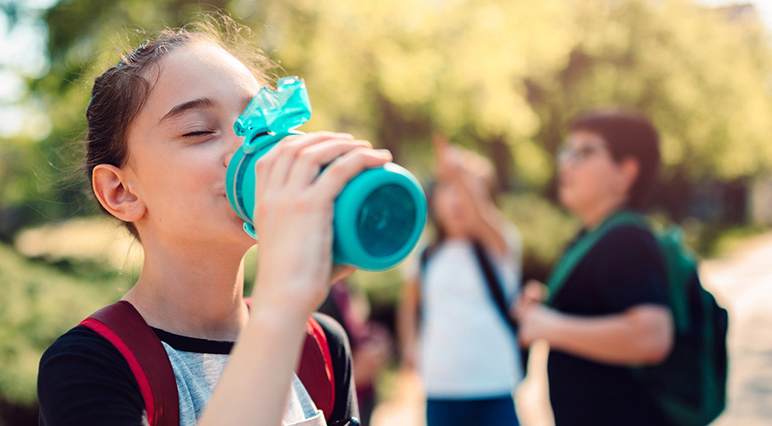 girl drinking from a water bottle