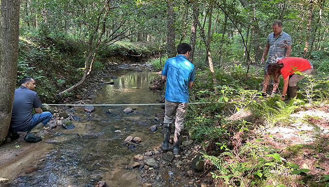 three people working in a stream