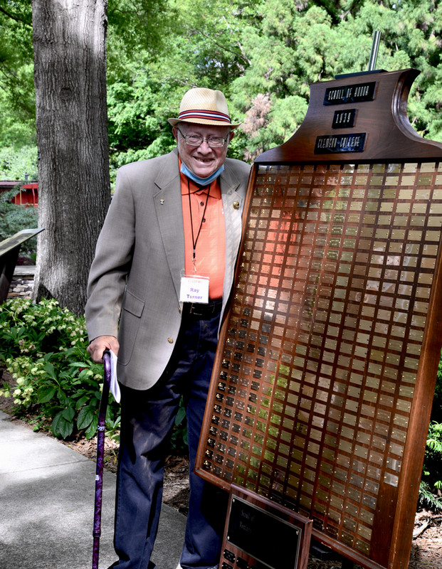 Ray Turner stands in front of Class of 39 plaque