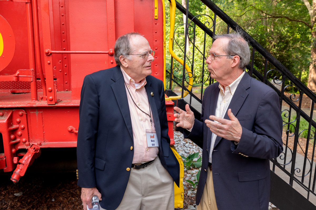 two men talking in front of the Class of '39 caboose
