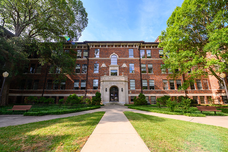 Sirrene Hall, a historic brick building on the Clemson University campus with a well-maintained pathway and lush greenery.
