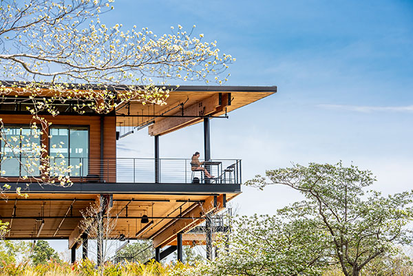 A student sits on a balcony across from the lake during spring