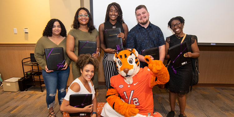 America Reads graduates pose at a reception with the tiger cub